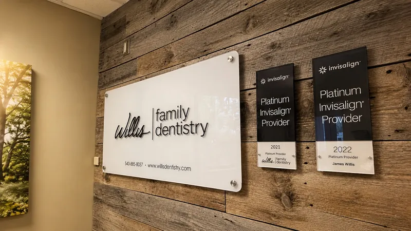 The Willis Family Dentistry logo wall with Platinum Invisalign Provider plaques